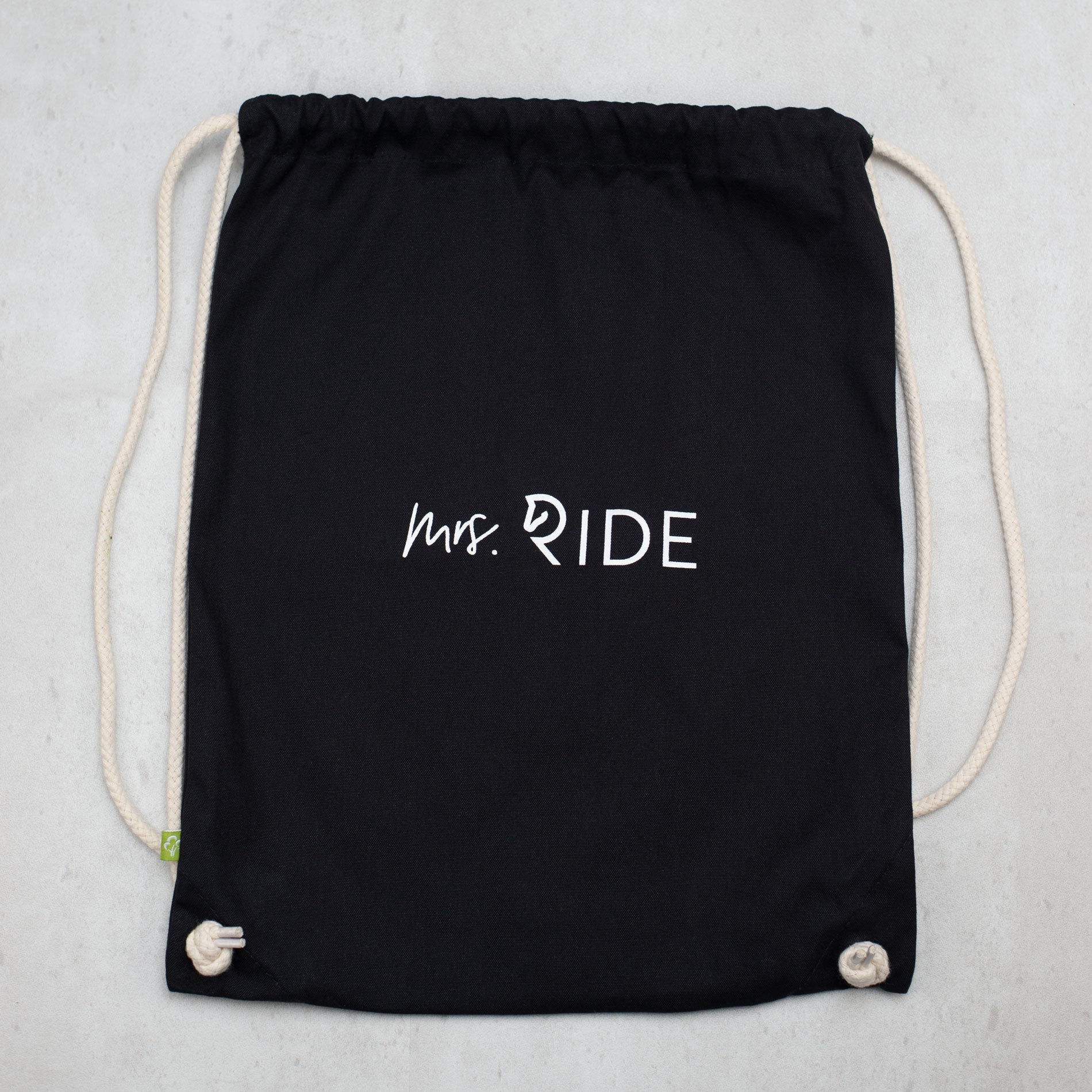 Schwarzer Rucksack auf grauem Untergrund 